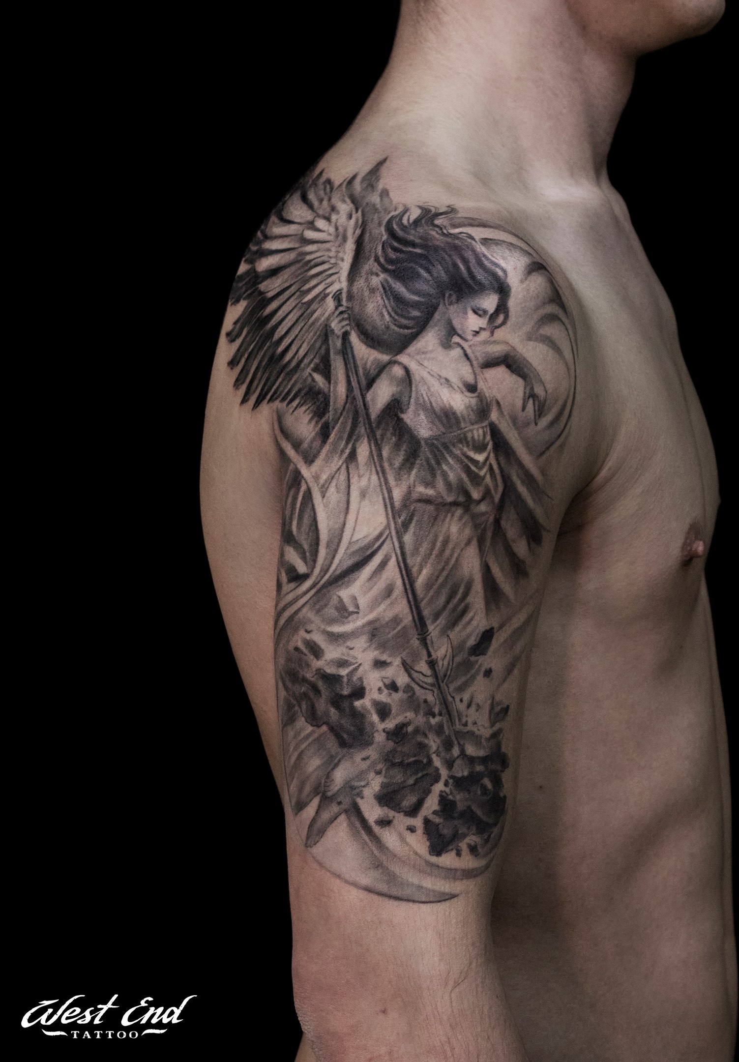 Ангел с крыльями и надписью в стиле «лайнворк» на спине парня