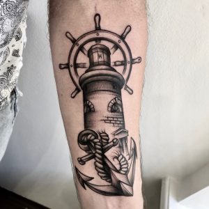 Ч/б татуировка маяка на мужском предплечье