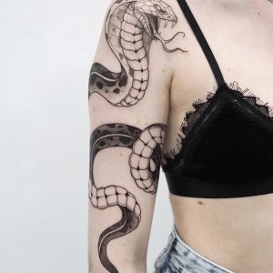 Татуировка змеи на женской руке