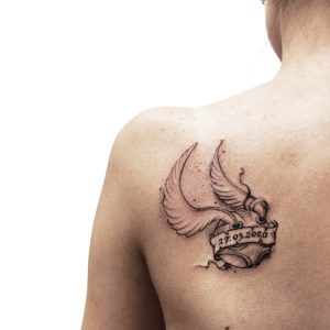 Татуировка снитч на женском плече